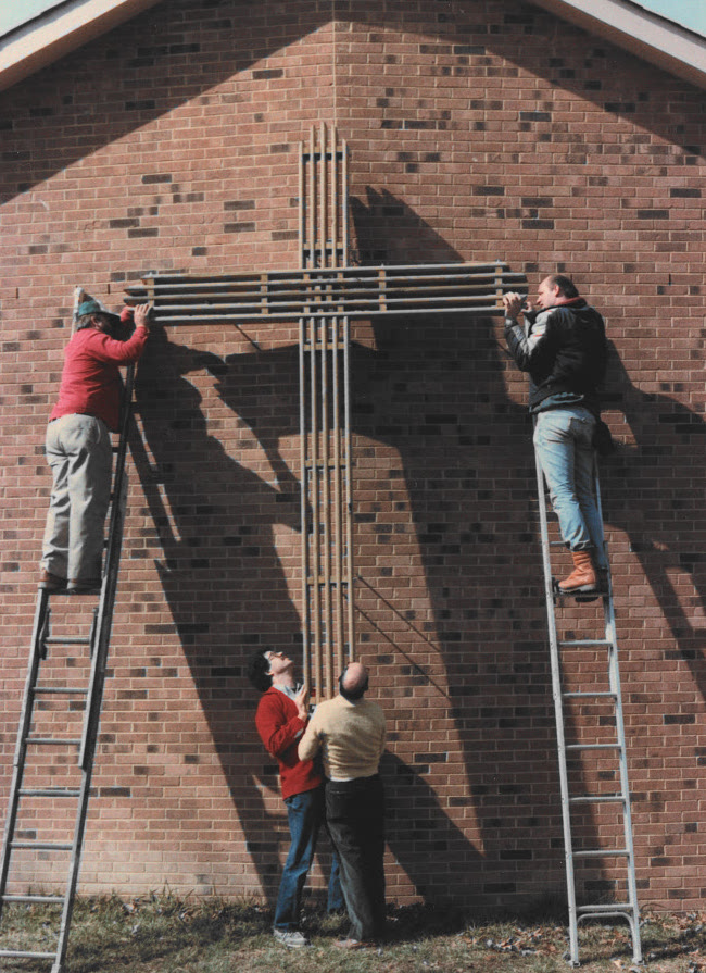 cross being mounted to building
